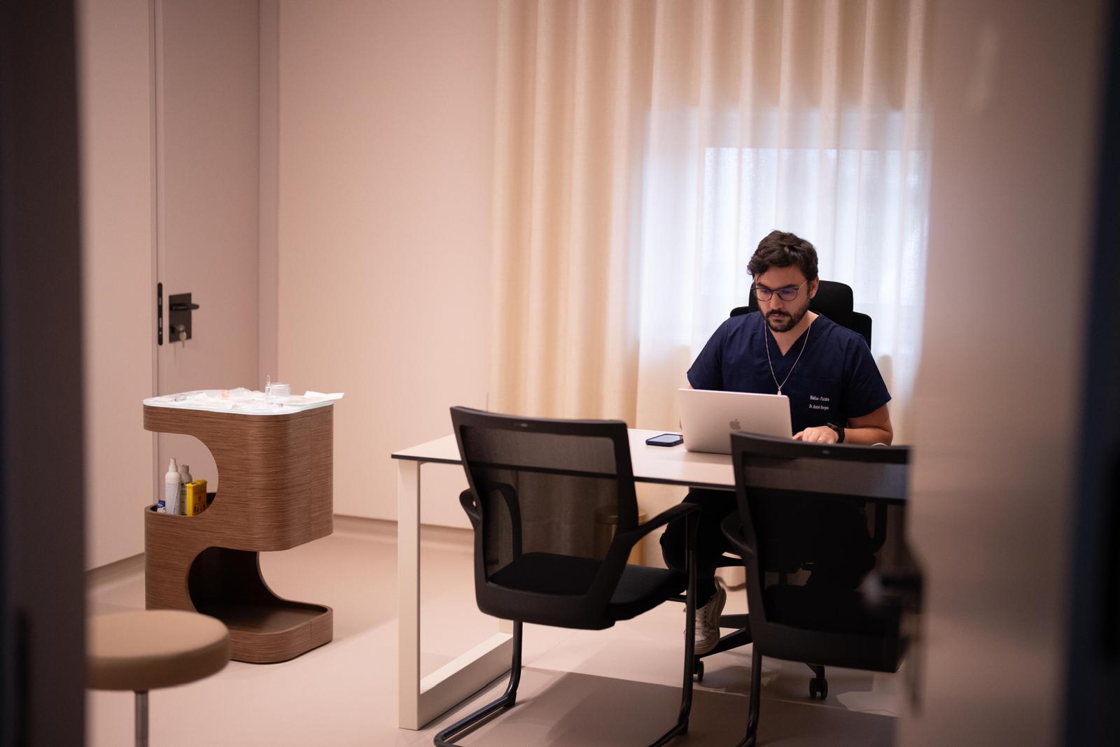 Gabinete de consulta com secretária, cadeiras e marquesa